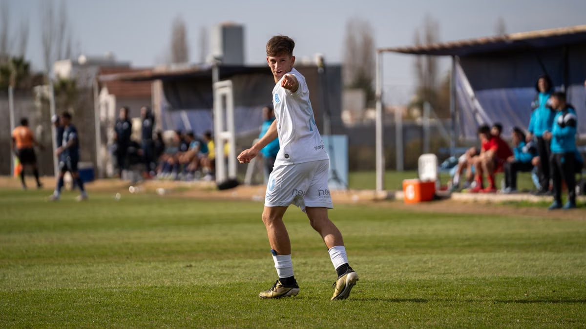 A soccer player in action, pointing during a match on a sunny day.